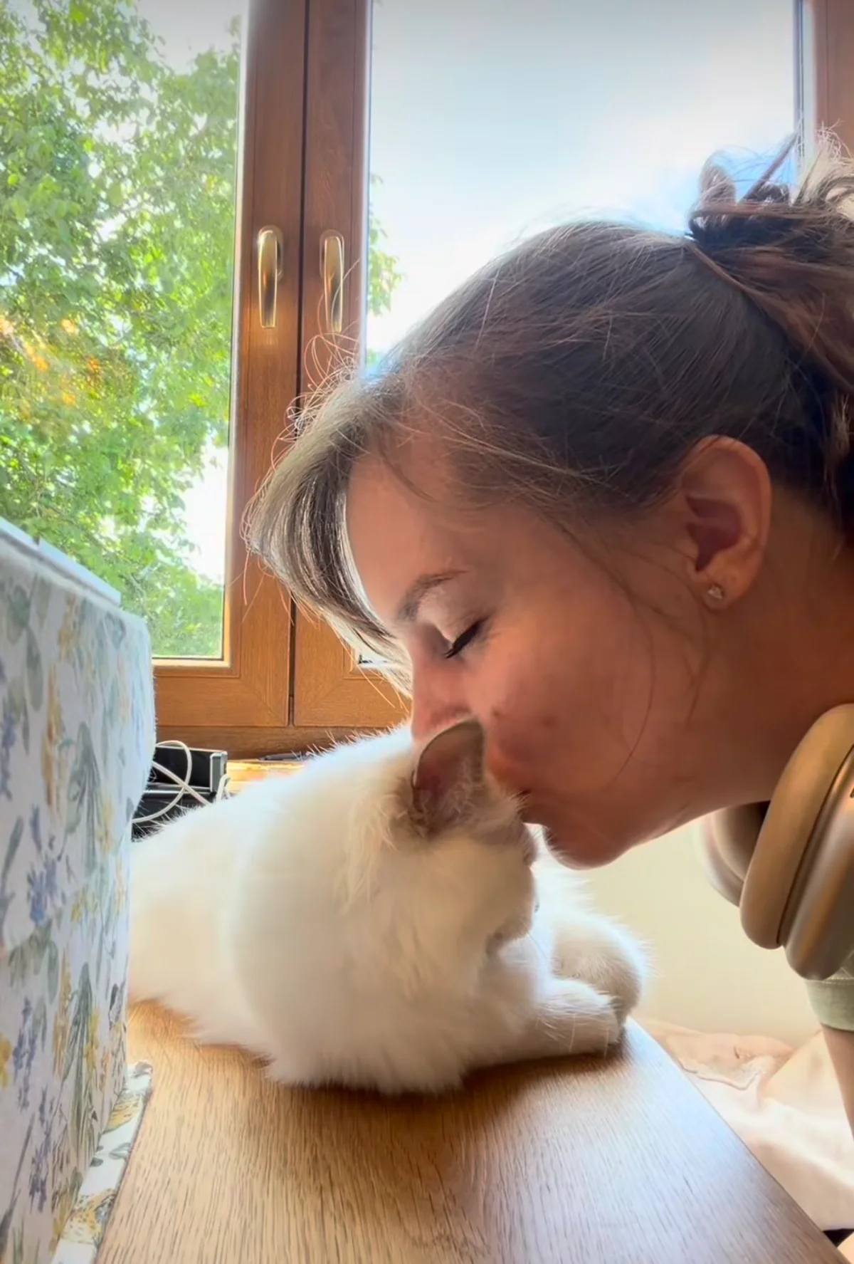 Ramona küsst ihre Katze auf der Fensterbank